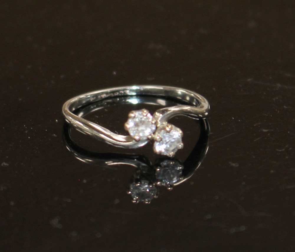 An 18ct and Plat, two stone diamond crossover ring, size P/Q, gross weight 2.5 grams.